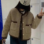 Veste femme courte en tissu peluche doux, couleur beige, avec un design moderne et une coupe confortable.