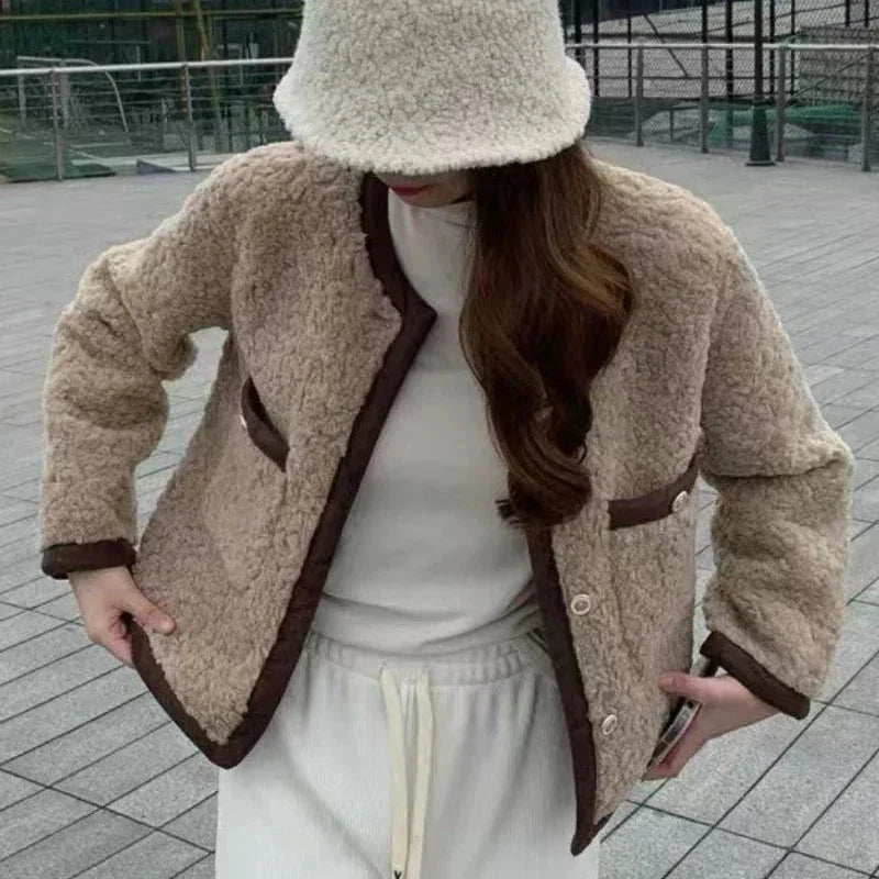 Veste femme courte en tissu peluche beige, avec deux poches et un design moderne.