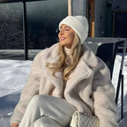 Veste teddy crème pour femme en fausse fourrure, col à revers et poches latérales. Parfaite pour les journées fraîches.