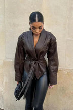 Veste femme marron foncé ceinturée, coupe ajustée, en matériau résistant avec col à revers classique.