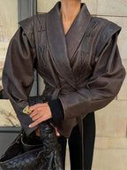 Veste femme marron foncé ceinturée, coupe ajustée, en matériau doux pour un style quotidien.