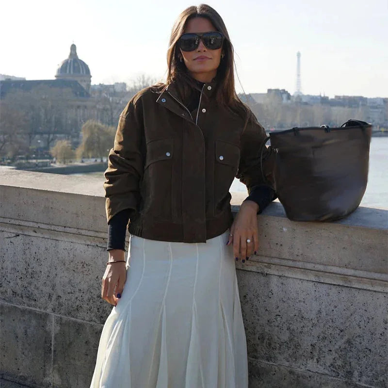 Veste femme motard kaki, en matériau résistant, avec poches avant et coupe asymétrique.