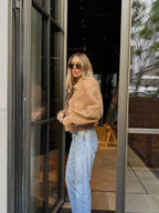 Veste courte en suédine beige pour femme avec zip et poches.