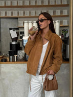 Veste courte en suédine marron pour femme avec zip et poches pratiques.