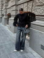 Veste noire femme avec manches en plumes et coupe moderne.