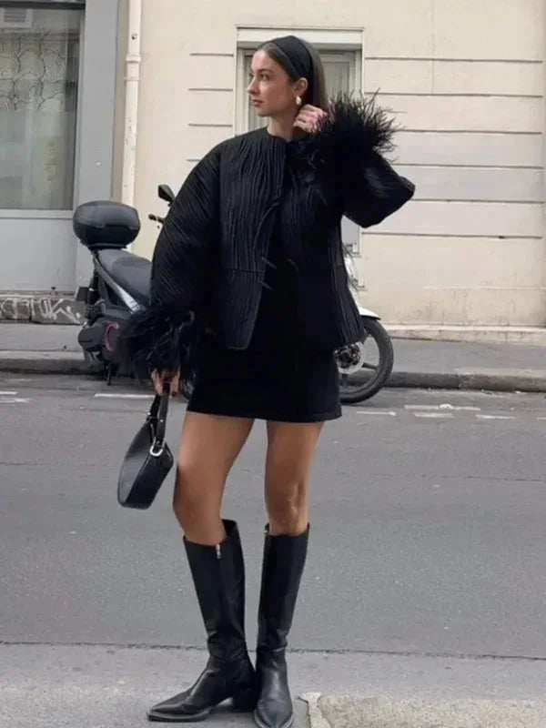 Veste noire femme avec poignets en plumes, coupe classique, idéale pour un look élégant.
