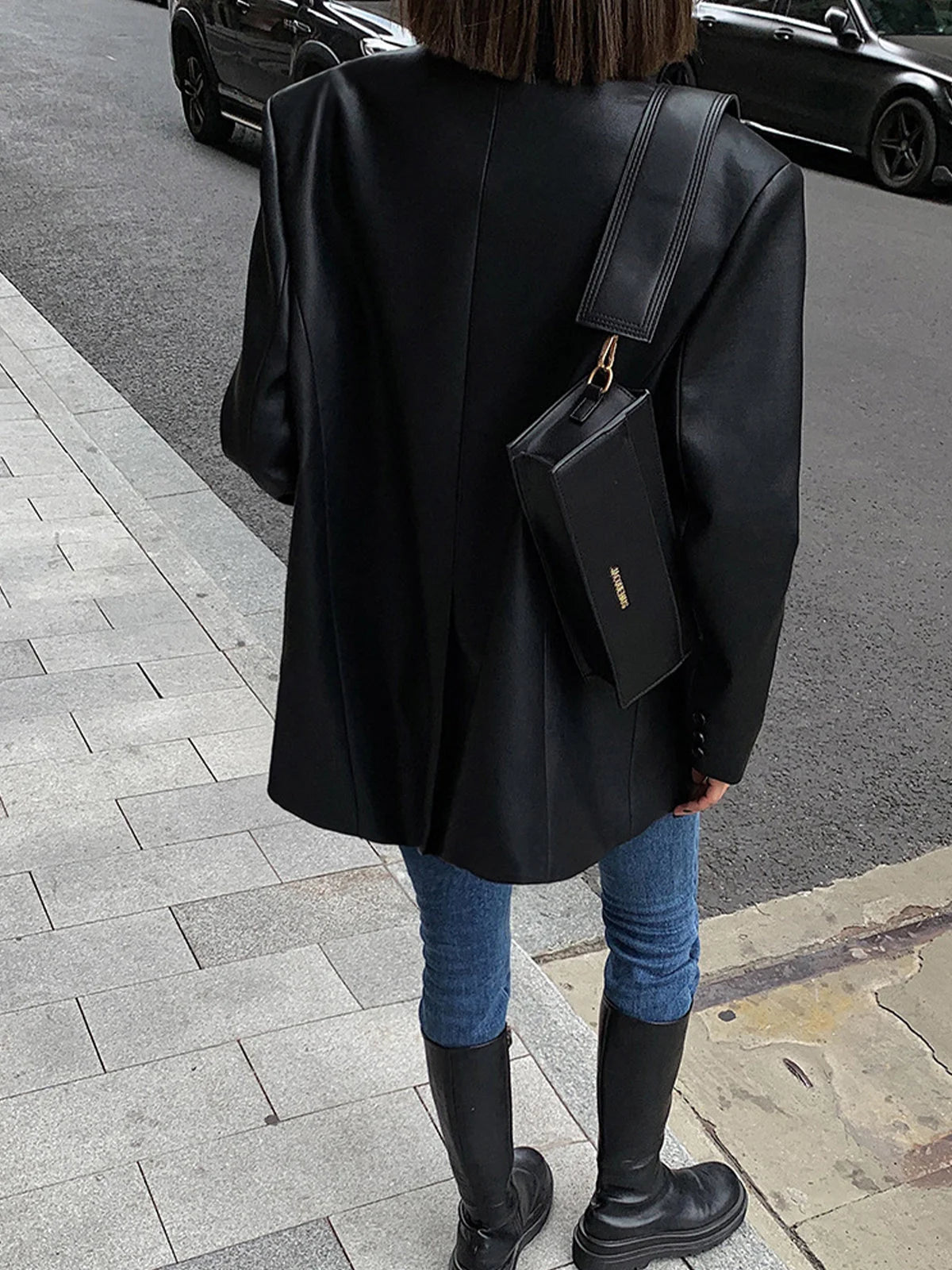 Veste surdimensionnée en simili cuir noir pour femme avec col moderne et style décontracté.