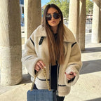 Veste teddy femme beige oversize avec accents noirs, en matière douce, parfaite pour des tenues décontractées.