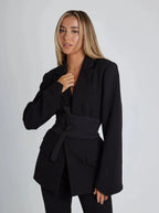 Blazer portefeuille noir pour femme, ceinture à nouer, manches longues et tissu doux, adapté pour le travail et les loisirs.